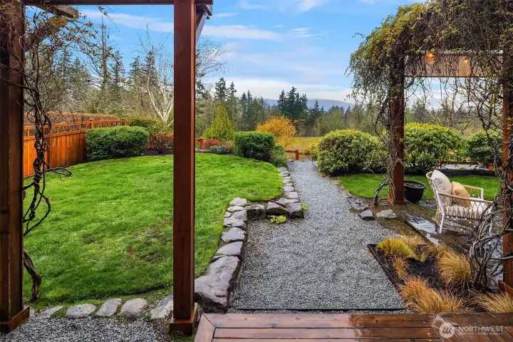 Custom designed backyard with covered trellis, fire pit area and gas line for grill hookup.