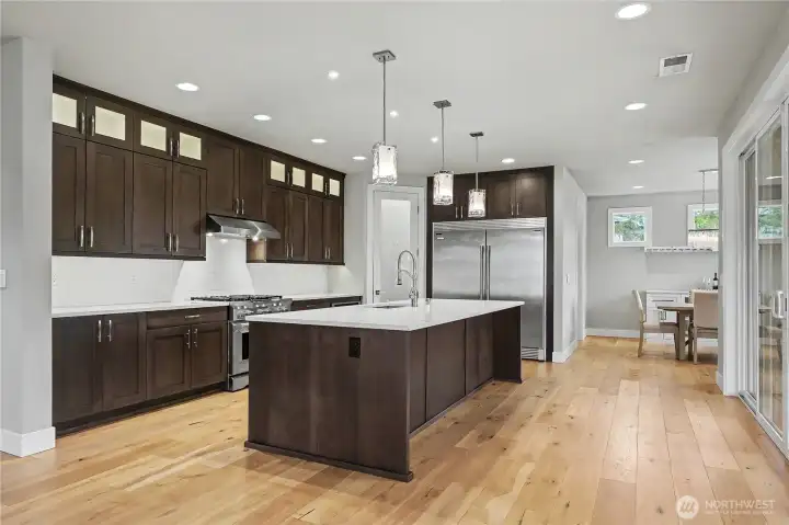 Kitchen view one, OMG where do I start?! MASSIVE island for incredible gathering and entertaining, custom cabinets with lighting throughout, walk-in pantry and a refrigerator/freezer worthy of this home.