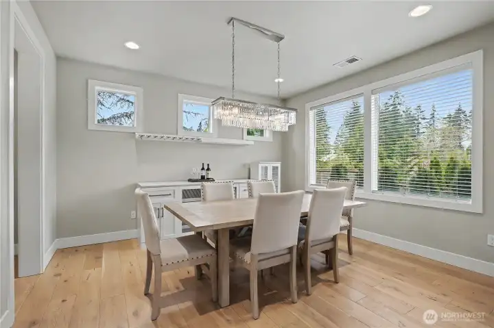 Formal Dining Room view, look at those windows! Sellers are including this dining set and buffet with the sale - just fits the home so perfectly. Hallway to your garage to your left.