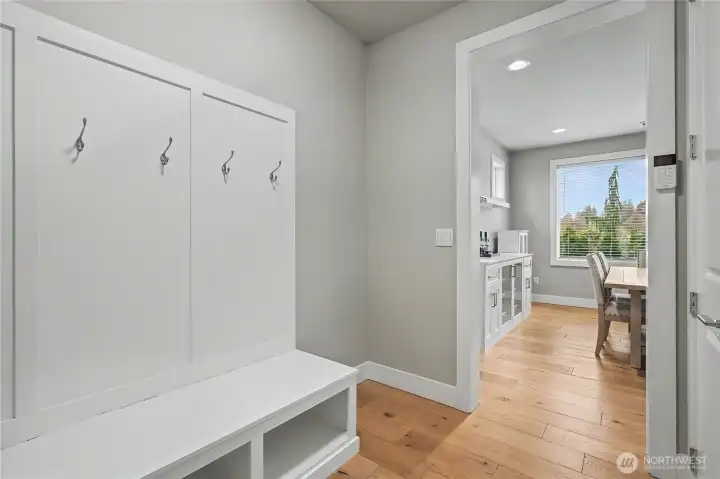 Hallway view off of your dining room to your garage, tremendous built-in coat rack & bench for easy on and off shoes and boots, no details missed in this luxury home.