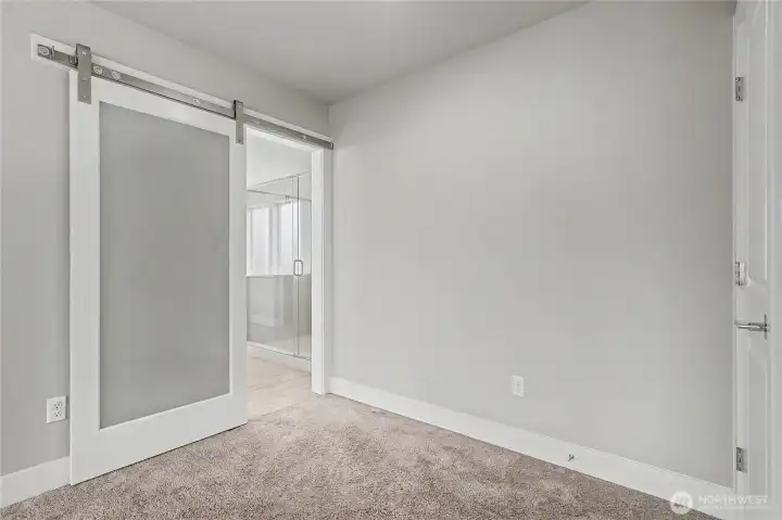View of your entrance to your primary ensuite bath, I love the barn door and that it is contemporary - matching the rest of the home perfectly.