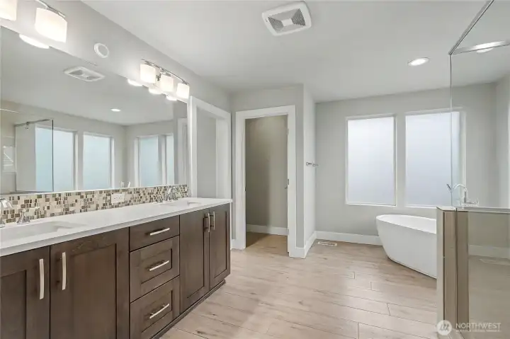 Primary Ensuite Bath view one, WOW, talk about an oasis! A true 5-piece bath with modern soaking tub on your right, separate larger shower, large double vanity, separate water closet and delightful walk-in closet, you will never want to leave!