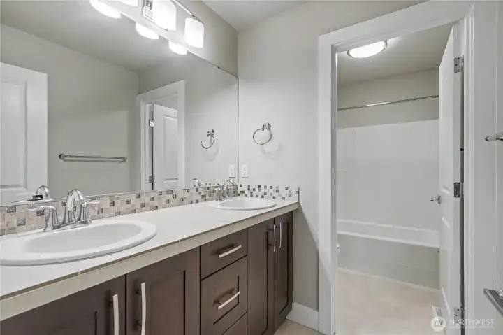 Upstairs kids/guest full bath with double vanity and separate shower/water closet area.