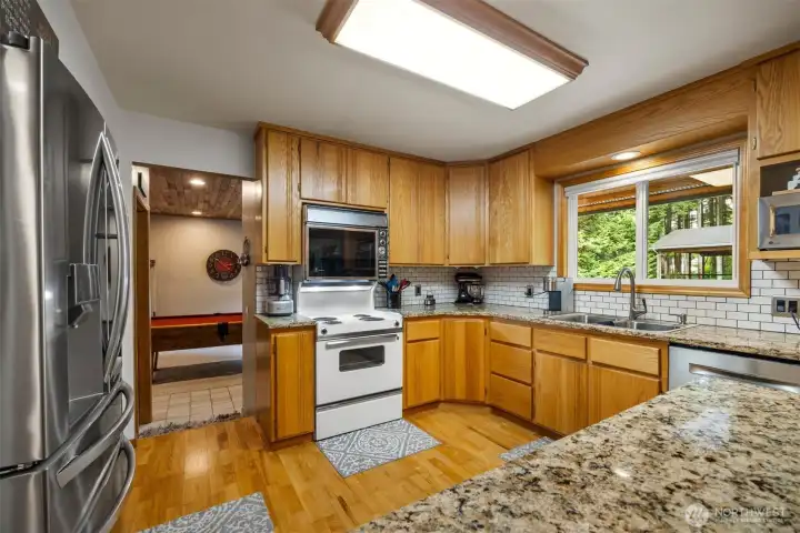 The electric range has a double oven and the seller loves it! There is a beautiful tile backsplash and an abundance of cabinet storage and counter space.