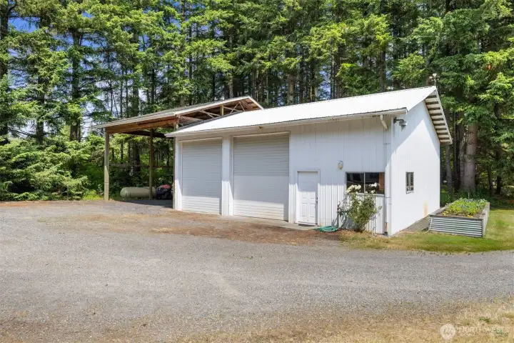 The shop is awesome and across the driveway from the home. There is a large raised vegetable garden at the south end, and beautiful roses at the front.