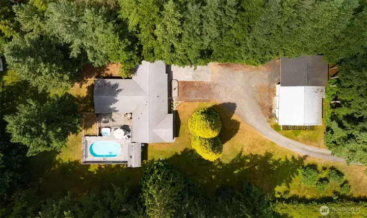 Looking down onto the 2.39 acres with the home and pool and large patio and deck area with the shop to the east of the home closer to Custer School Road.