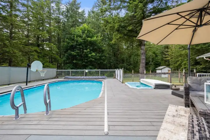 This pool is awesome! The deck wraps around the pool and the stairs are removable so that the cover can glide over to close it off. There is also a hot tub built in. Beyond the hot tub is a chicken coop and good shed.