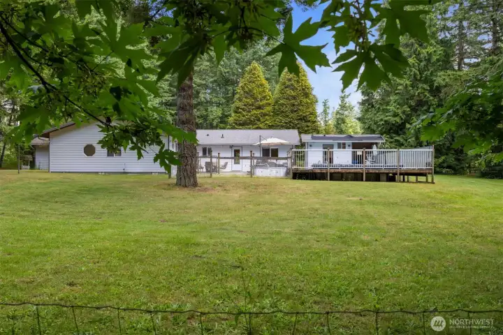 Looking at the back side of the home with the swimming pool, hot tub, pool house, large deck and patio which is fabulous outdoor living this time of the year!