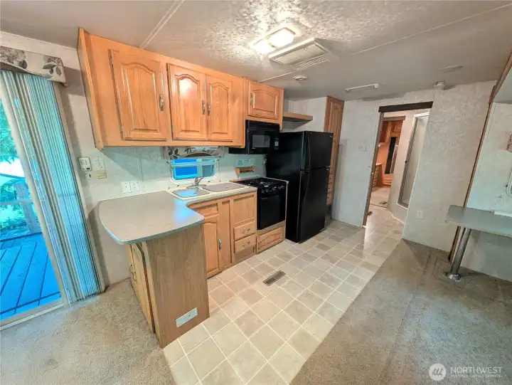 Full sized fridge, three burner stove top oven, and microwave.