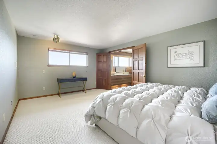 Bright bedroom with neutral finishes, ample closet space, and a water view. Bright bedroom with neutral finishes, ample closet space, and a water view.