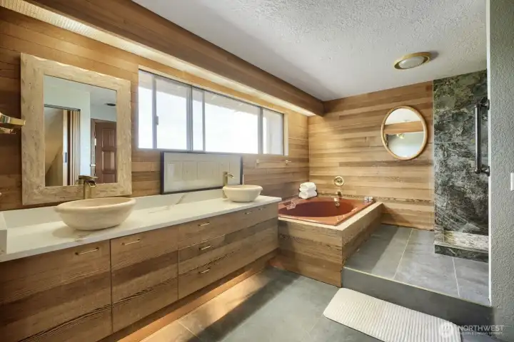 Primary bathroom featuring a soaking tub, separate walk-in shower, dual-sink vanity, and warm wood finishes. Primary bathroom featuring a soaking tub, separate walk-in shower, dual-sink vanity, and warm wood finishes.