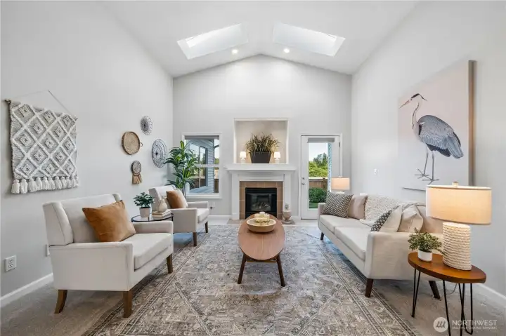 Proceed down the hall to this grand living room with vaulted ceilings, a cozy gas fireplace, and picture windows that frame beautiful territorial views.