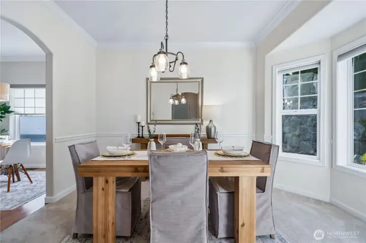The eating nook flows directly into the formal dining room, which also features a bay window and elegant chair rail detailing.