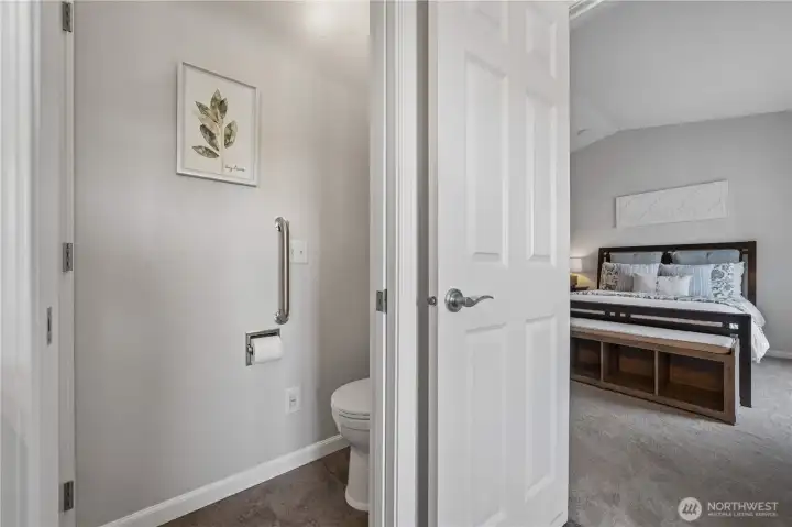 The commode is conveniently tucked away behind a pocket door for added privacy.