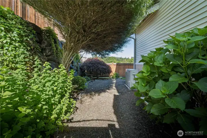 An enchanting side garden and convenient gate provide easy access to the front of the home.