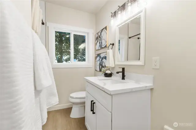 Second view of new bath on main level with cute vanity quartz counters modern lighting and oil rubbed bronze fixtures