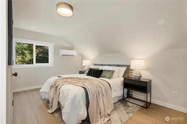 Here is primary bedroom upstairs with attached ductless mini split for heat and cooling year around.  Next picture show large sitting room or second bonus room next to primary bedroom for relaxing or watching movies together.  There is good sized primary bathroom and walk in closets also