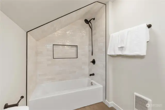 Here is another view of primary bathrooom with large glass tiled shower and oil rubbed bronzed shower fixtures