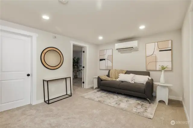 Here is lower level living room surrounded by 2 other bedrooms.  The closed door is large pantry or storage closet Check out the 3rd ductless mini split in ceiling to share lots of warm and cool air when neeed.  This home has it all
