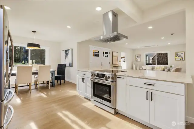 Here is one of many kitchen views in this large entertaining area area loaded with updates.  Check out the large kitchen island with white quartz counters,ss appliances with hood,white painted cabinets, oil rubbed bronzed fixtures and lots of windows to keep it light