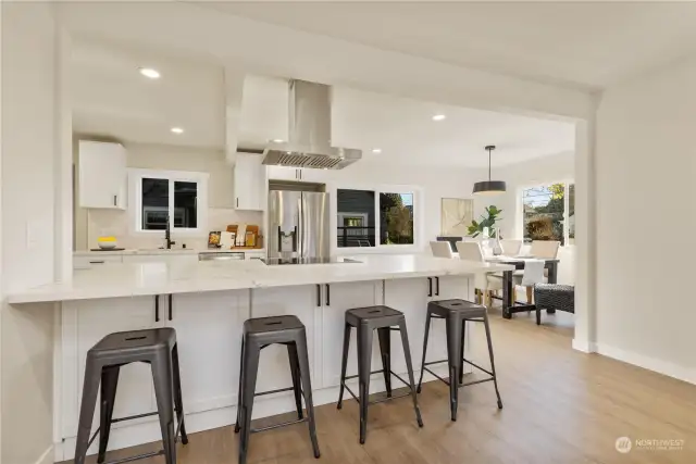 See this beautiful modern kitchen view loaded with stunning designs and lots of cabinets for storage.  The bar is open to the great room dining room and big enough for 4-5 bar stools of seating