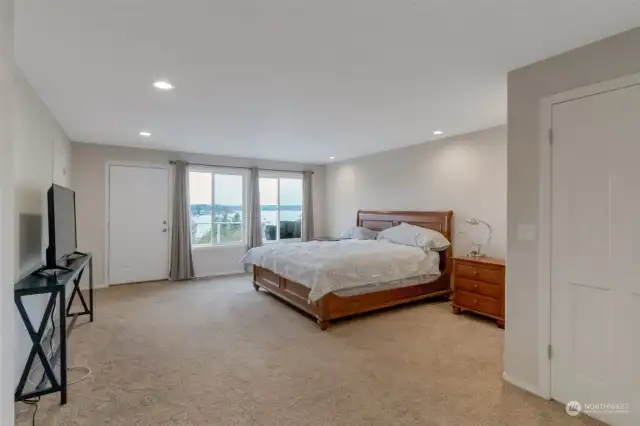 MAIN LEVEL Spacious primary suite welcomes you in through french doors to a lovely sitting area, then on to the beautiful lake views and access to the deck as well as the ensuite bathroom.