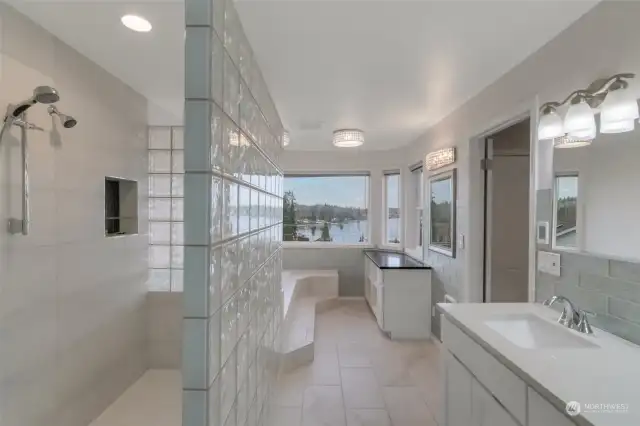 Stunning primary bath with double sinks, lots of storage PLUS a vanity space. Wrapped in windows, enjoy a nice soak while gazing at the relaxing Lake and Mountain views. Radiant heating in the tile floors! Large walk in tiled shower! This primary bath has it ALL!