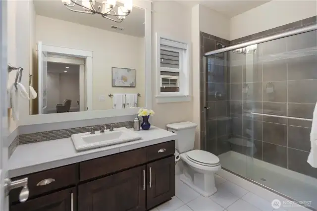 Main level three-quarter bath, tile floor and tile shower surround.