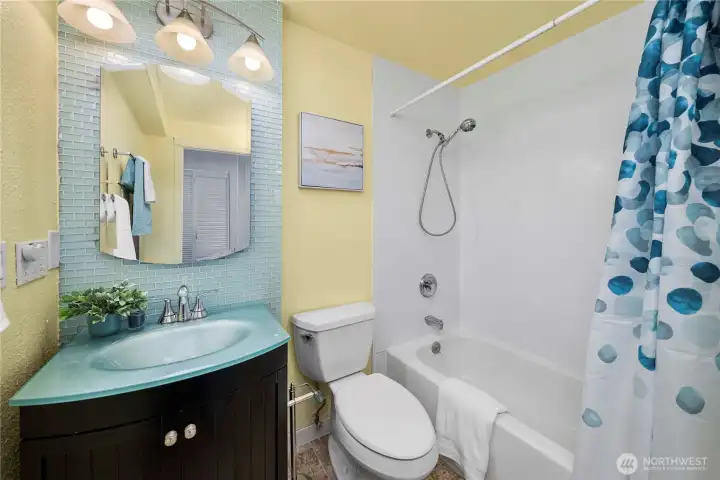 Full hall bath with medicine cabinet nook behind the door.