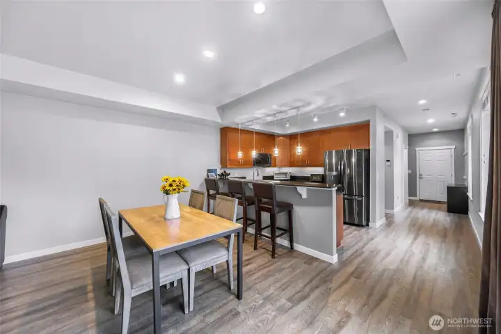 Open concept dining and kitchen layout with stylish lighting and plenty of room to gather.