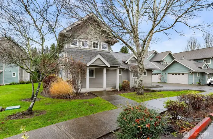 Front entrance with covered porch and easy access to community paths, open lawns, and guest parking.