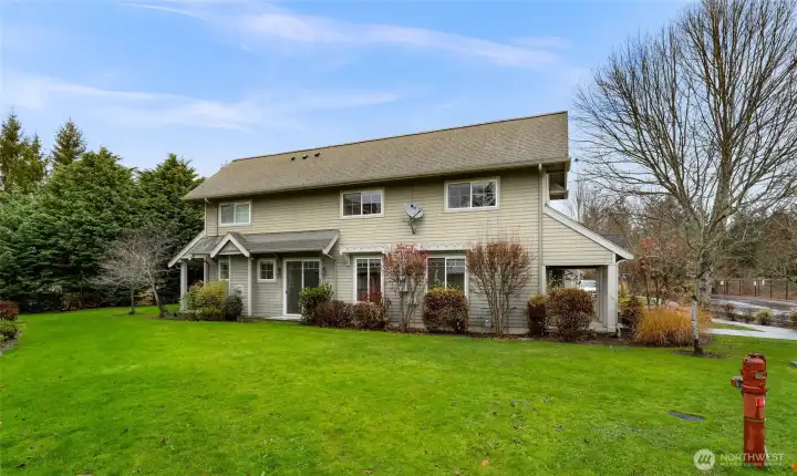 Community setting with well maintained grounds, mature landscaping, and generous lawn areas surrounding the building.