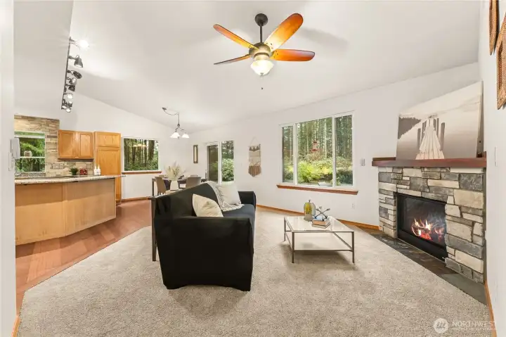 Enjoy comfort and connection in this airy living room, complete with ceiling fan and a warm stone-wrapped fireplace.