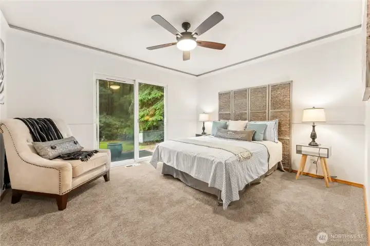 Your private retreat: primary suite with ensuite, walk-in closet, and sliding door to the patio and backyard.