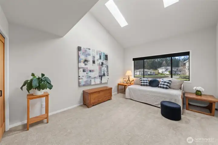 Second bedroom with vaulted ceiling featuring two skylights and custom closet