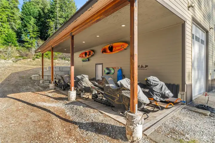 2 large carports suitable for RV parking. One is set up perfectly for snowmobile parking with wood decking.