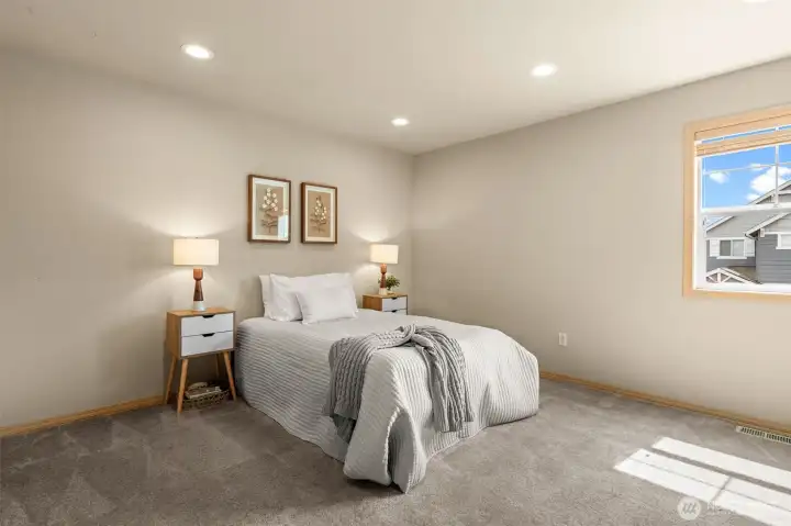 Comfort meets style in this spacious bedroom, featuring plush finishes and a layout that easily accommodates additional seating or a vanity