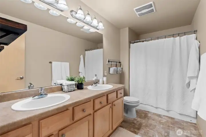Bright and airy, this centrally located bathroom offers a fresh aesthetic with plenty of counter space and an easy-to-clean layout