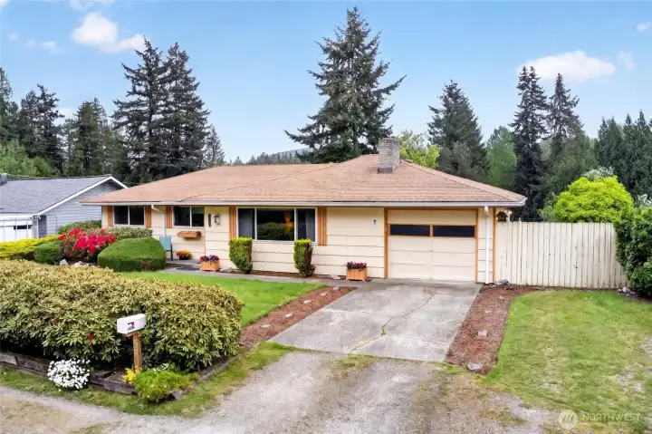 This single-level rambler offers easy curb appeal with its level driveway, attached 1-car garage, and well-kept front yard framed by established hedges and flowering shrubs. The simple, timeless exterior sets the stage for convenient living in a peaceful neighborhood setting.