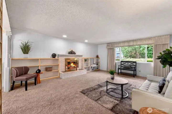 Bright and inviting living room features a large picture window, neutral paint, and cozy wall-to-wall carpet, creating a comfortable gathering space that feels open and welcoming. If you don't like the carpet there is real hardwood floors underneath.
