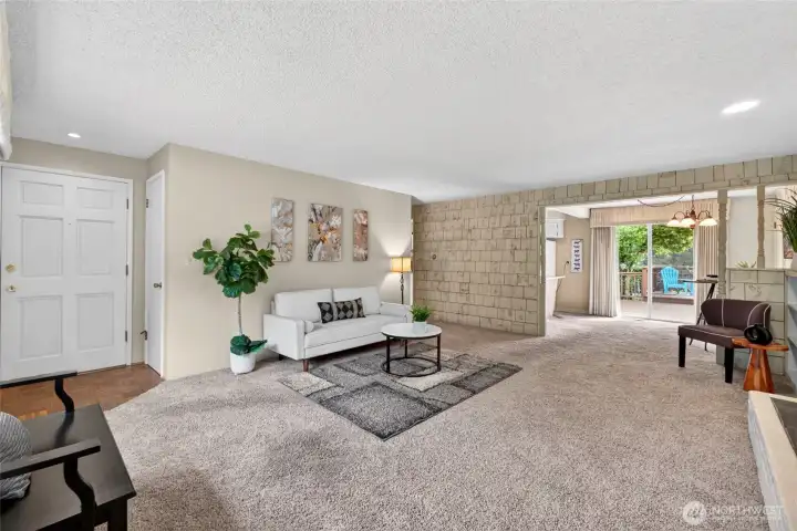 Spacious living room flows seamlessly into the dining area, with a wood-burning fireplace, built-in shelving, and sliders to the back deck for easy indoor–outdoor entertaining.