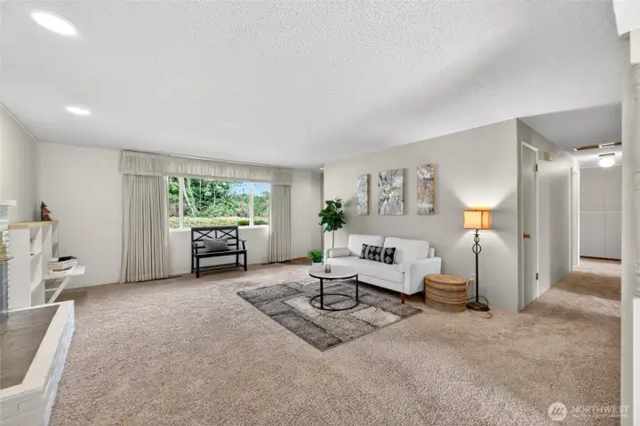 Crisp, neutral walls and plush carpeting set a relaxed tone in this front living area, framed by the classic paneled entry door and a stylish seating vignette. An open pass-through to the dining space draws the eye toward the back deck and makes the entire main living area feel connected.
