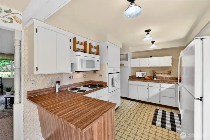 Functional kitchen layout with abundant cabinet storage, generous counter space, and a breakfast bar perfect for casual meals.