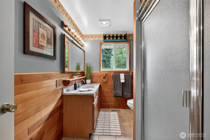 Updated bathroom featuring warm wood accents, natural light, and a clean modern feel.