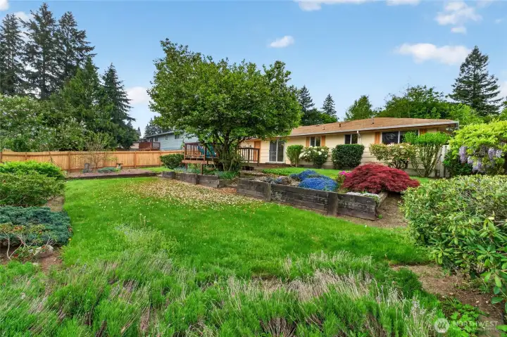 Expansive yard with colorful landscaping, garden areas, and generous outdoor space for relaxing, entertaining, or play.
