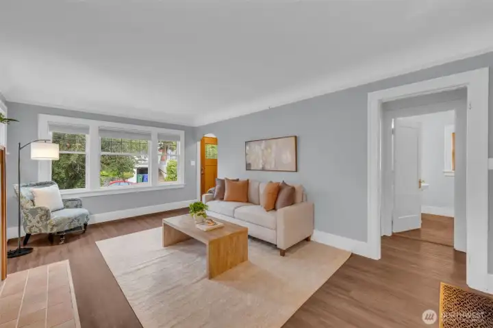 The living room features vintage leaded glass windows and coved ceiling with picture hanging rail. new luxury vinyl flooring flows thru out the main level.