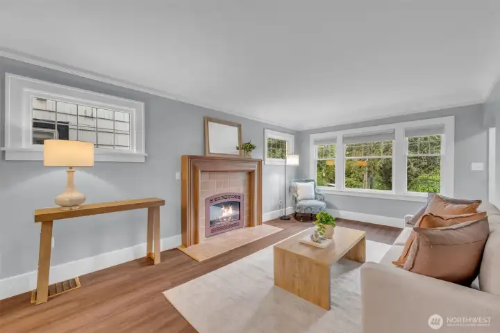 Living room is anchored by tiled, gas fireplace with mantle. Note the leaded glass windows on either side