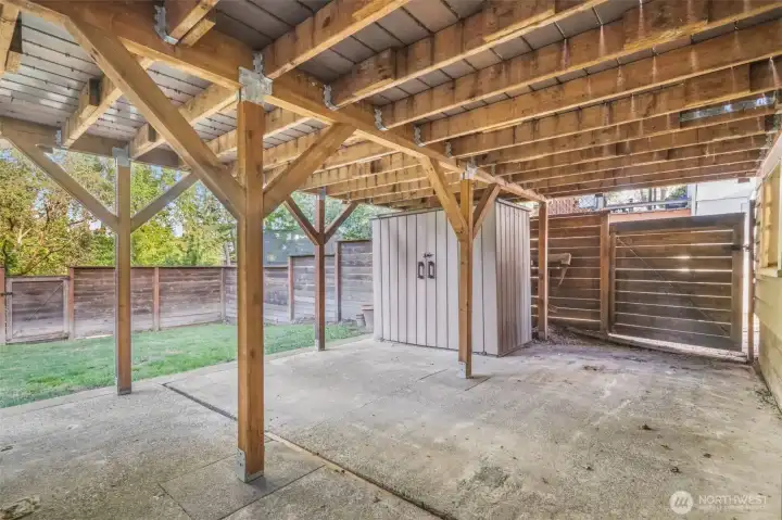 Large patio sits under deck and offers two storage sheds that stay with the property