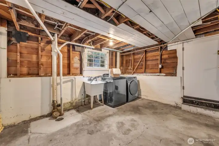Laundry room offers utility sink and door to backyard patio