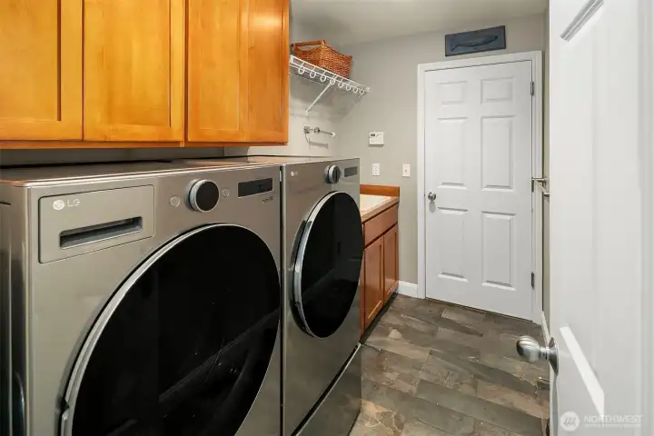 Laundry with functional laundry deep sink and door to the oversized three car garage. Laundry with functional laundry deep sink and door to the oversized three car garage.